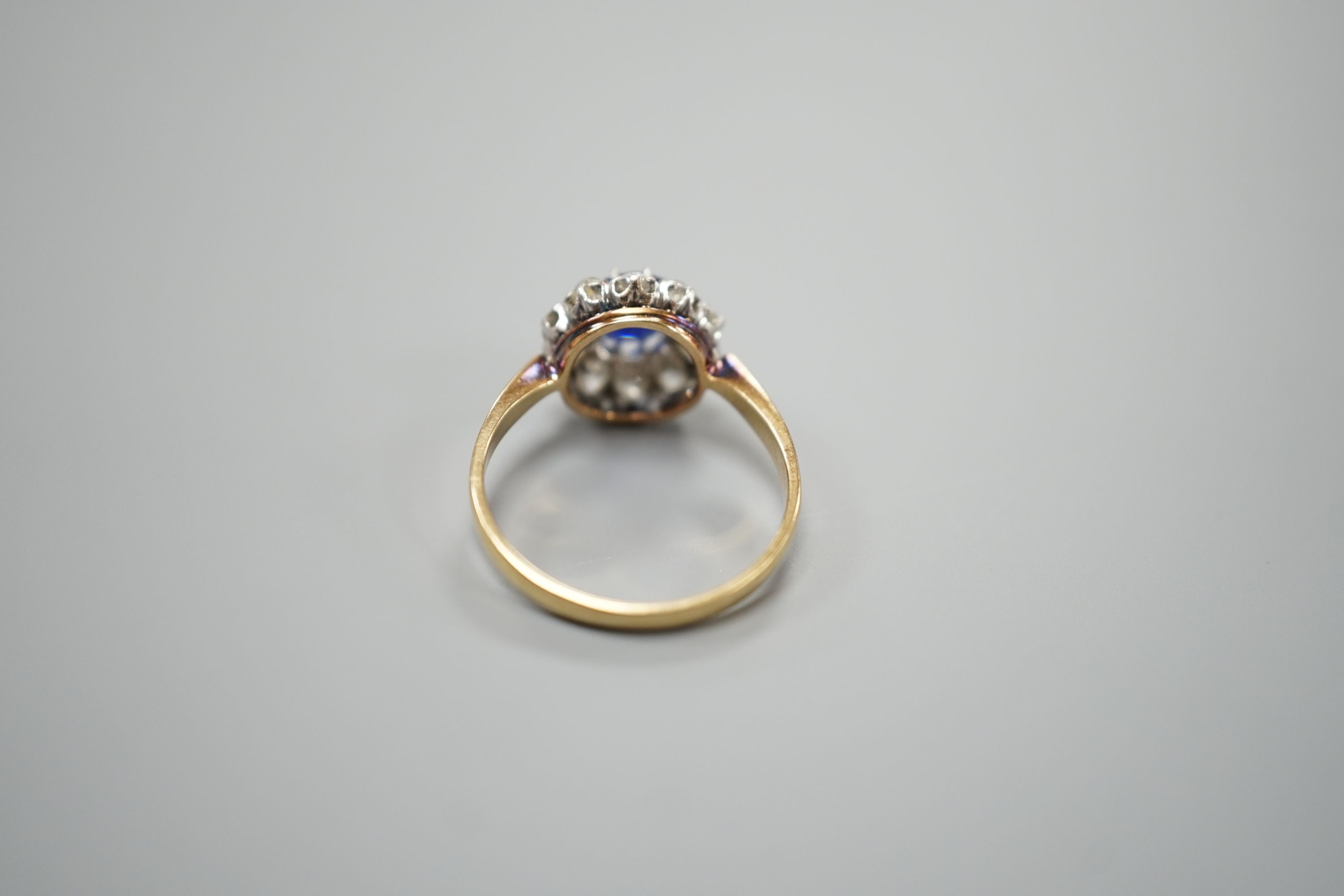 A yellow metal, sapphire and diamond set circular cluster ring, size N/O, gross weight 3.1 grams.
